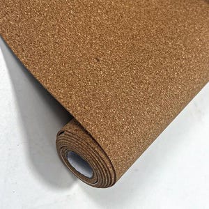 以下が含まれることがあります： 暖かみのある茶色の天然コルク素材のロール。コルクシートは部分的に広げられており、その質感のある表面と丸まった端が見えています。この素材は柔軟性があり、さまざまなクラフトやデザインプロジェクトに適しているようです。