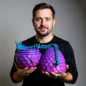May include: A purple and blue dragon egg toy, split in half, with a dragon skeleton emerging from the top. The egg is held open, revealing the inside. The text "mystery egg" is visible on the side of the egg.