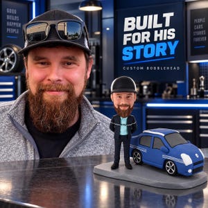 May include: A custom bobblehead figure featuring a bearded person wearing a black cap, a light blue shirt, and a dark jacket, standing next to a blue sedan with white side stripes on a gray base, with the text BUILT FOR HIS STORY CUSTOM BOBBLEHEAD.