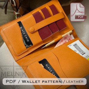 Op de afbeelding: Een open oranje leren portemonnee met meerdere compartimenten. De portemonnee bevat een zwarte kaart, paspoorten en een pen. De tekst "BLACK CARD" is zichtbaar op de kaart. De onderkant van de afbeelding bevat de tekst "PDF / WALLET PATTERN / LEATHER".