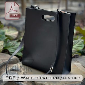 May include: Black leather tote bag with a handle cutout and a long shoulder strap. The bag has a rectangular shape and a minimalist design. The image also includes a PDF icon and the text "PDF / WALLET PATTERN / LEATHER".