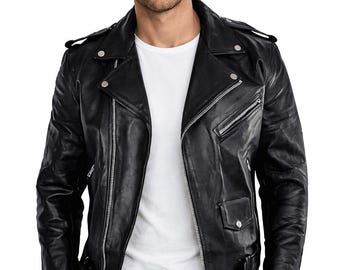 Puede incluir: Chaqueta de cuero negra de estilo motero con cremalleras y broches plateados. La chaqueta tiene cuello con solapas, charreteras y cinturón en la cintura. El modelo lleva una camiseta blanca y vaqueros negros.