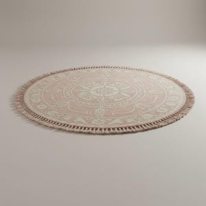 May include: A round, pink rug with a cream-colored floral pattern in the center. The rug has a fringe border and is approximately 60 inches in diameter. The rug is suitable for a living room or bedroom.