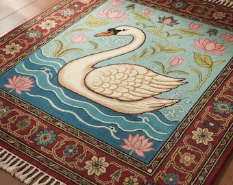 May include: A rectangular rug featuring a swan swimming on blue water, surrounded by pink lotus flowers and green foliage against a light blue background. The rug has a red border with floral patterns and white fringe.