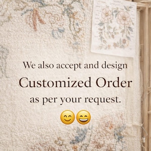 May include: Cream-colored textile with floral embroidery in muted tones of blue, orange, and green. The text reads "We also accept and design Customized Order as per your request." Two smiling face emojis are at the bottom.