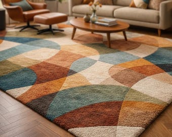 May include: A colorful area rug with a geometric pattern of overlapping arcs in shades of blue, orange, brown, and cream. The rug is placed on a hardwood floor, creating a warm and inviting living space.