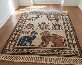 May include: Beige rectangular rug with a repeating pattern of stylized animals and insects in brown and navy blue. The rug has a fringe along the bottom edge and a border with a repeating arrow design. The rug is placed on a hardwood floor.