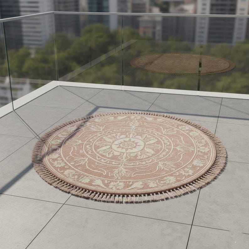 May include: A round, blush-colored rug with a detailed floral and geometric pattern. The rug has a fringe border and is placed on a tiled surface. The rug's diameter is approximately 60 inches.