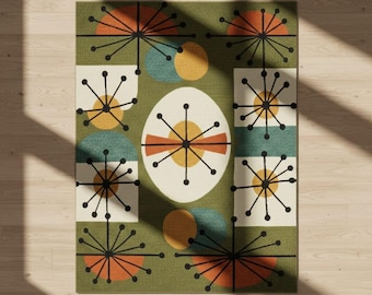 May include: A rectangular area rug with a mid-century modern design. The rug features a green background with geometric shapes in orange, yellow, teal, and white. The design includes starburst and oval patterns. The rug is likely made of woven material.