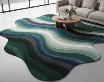 May include: A large, uniquely shaped area rug with a flowing, wave-like design. The rug features bands of color in shades of green, blue, gray, and white. The rug is placed in a modern living room setting with a sofa and coffee table.