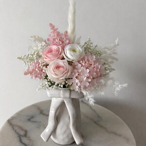 Könnte beinhalten: Rustikales Holzschild mit dem weißen Schriftzug "Welcome to our home". Das Schild hat eine Used-Optik und ein schlichtes, einladendes Design.