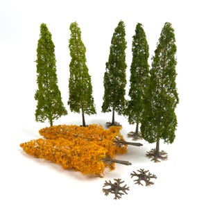 May include: A collection of model trees including five upright trees with green foliage and two horizontal trees with orange foliage. Each tree features a brown trunk and a separate brown plastic base with a star-shaped root structure.