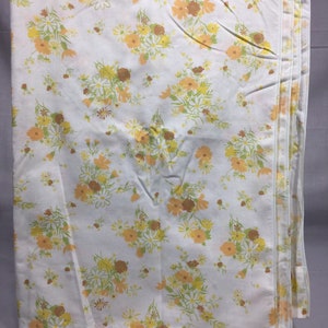 Pu&ograve; includere: Un lenzuolo bianco con un motivo floreale in tonalit&agrave; di giallo, arancione e verde. I fiori sono piccoli e sparsi su tutto il lenzuolo.