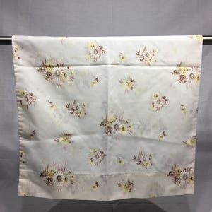 May include: White cotton pillowcase with a floral pattern of yellow, pink, and brown flowers. The flowers are arranged in small bouquets scattered across the fabric.