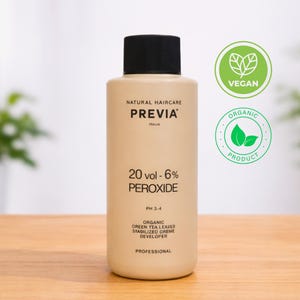 Könnte beinhalten: Beige Flasche PREVIA 20 vol - 6% Peroxid Haarentwickler. Die Flasche hat einen schwarzen Deckel und trägt die Aufschrift "NATURAL HAIRCARE" und "ITALIA". Enthält auch die Labels "VEGAN" und "ORGANIC PRODUCT". Für den professionellen Gebrauch.