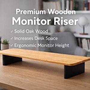 May include: A wooden monitor riser with a light brown oak top and black legs. The text on the image reads "Premium Wooden Monitor Riser" and highlights features like solid oak wood, increased desk space, and ergonomic monitor height.