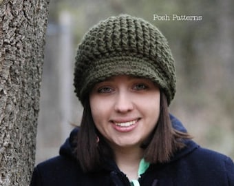 Puede incluir: Una mujer lleva una boina de punto de color verde oscuro con una visera. La boina tiene un patrón de punto texturizado. Lleva una chaqueta azul oscuro.