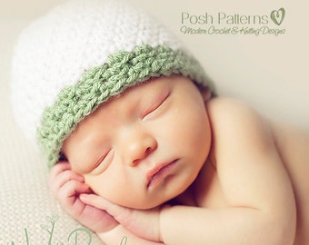 Puede incluir: Un bebé durmiendo con un gorro de crochet blanco y verde. El gorro tiene la parte superior blanca y el borde verde. El bebé está acostado de lado con la cabeza apoyada en el brazo.
