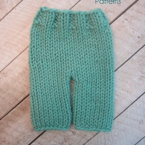 Puede incluir: Pantalones de bebé de punto color turquesa. Los pantalones están hechos con un punto de tejido sencillo y tienen una pierna recta.