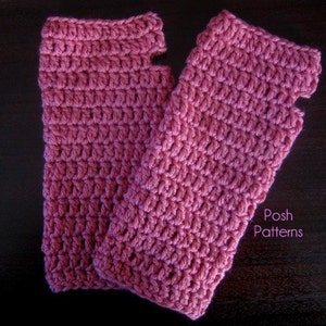 Peut inclure: Une paire de mitaines en crochet de couleur rose foncé. Les mitaines sont réalisées avec un point simple et ont un trou pour le pouce. Les mitaines sont présentées sur une surface en bois foncé.