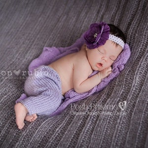 Puede incluir: Una bebé durmiendo con una diadema de punto morado con una flor en la parte superior, tumbada sobre una manta de punto morado.