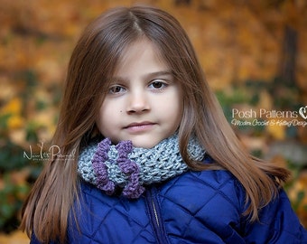 May include: A young girl with long brown hair wearing a blue quilted jacket and a gray and purple crocheted scarf.  The scarf has a ruffled design.