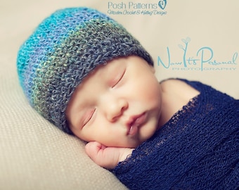Könnte beinhalten: Ein schlafendes Baby trägt eine blaue, grüne und graue Häkelmütze und ein marineblaues Swaddle. Das Baby liegt auf einer beigefarbenen Oberfläche. Der Text "Now It's Personal Photography" ist im Hintergrund sichtbar.