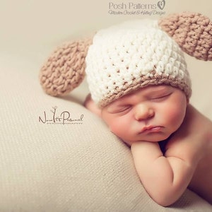 May include: A white and brown crocheted baby hat with floppy ears. The hat is on a sleeping baby's head.