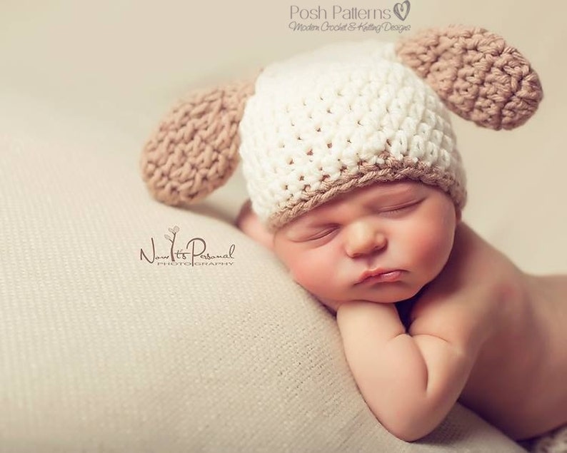 May include: A white and brown crocheted baby hat with floppy ears. The hat is on a sleeping baby's head.