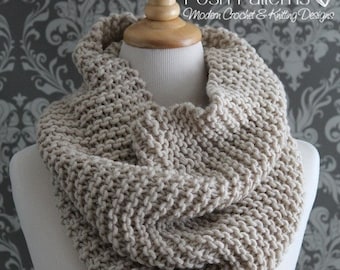 Könnte beinhalten: Ein beigefarbener gestrickter Infinity-Schal auf einer weißen Puppe. Der Schal ist mit einem einfachen Stichmuster gearbeitet und ein klassisches Winteraccessoire.