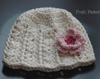May include: A white crocheted hat with a pink crocheted flower on the side. The hat is made with a simple stitch pattern and has a wide brim.