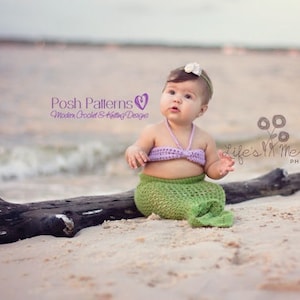 May include: A baby girl wearing a purple crochet top and a green crochet mermaid tail sits on a driftwood log on a sandy beach. The baby is wearing a white flower headband. The text "Life's Mementos Photography" is visible in the background.