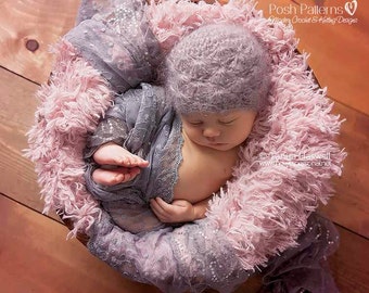 May include: A newborn baby wearing a soft, gray crocheted hat and a delicate, gray lace wrap. The baby is lying on a fluffy, pink faux fur prop.