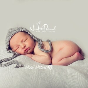 May include: A newborn baby wearing a gray knitted hat with a long tassel sleeps on a white blanket. The baby is curled up with their arms and legs tucked in. The text "Now It's Personal Photography" and "Posh Patterns" is visible in the image.