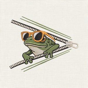 Peut inclure: Un motif de broderie représentant une grenouille verte portant des lunettes de soleil à monture orange, sortant d'entre deux fermetures éclair ouvertes noires et blanches. La grenouille a un ventre clair et des taches vert foncé sur le dos.