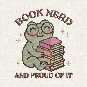 May include: An embroidered design showing a cartoon frog in glasses, embracing a pile of books. The text reads "BOOK NERD" above and "AND PROUD OF IT" below. The frog is green with rosy cheeks, and the books are pink and orange.