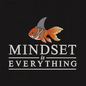May include: An embroidered design on a black fabric background featuring an orange goldfish wearing a grey shark fin hat. Below the fish, the text reads MINDSET is EVERYTHING in white capital letters, separated by two horizontal white lines.