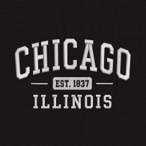 Op de afbeelding: Een zwart stoffen oppervlak met wit geborduurde tekst. Het woord CHICAGO staat in een boog bovenaan, gevolgd door een rechthoekig embleem met de tekst EST. 1837, en het woord ILLINOIS is in een rechte lijn onderaan geborduurd.
