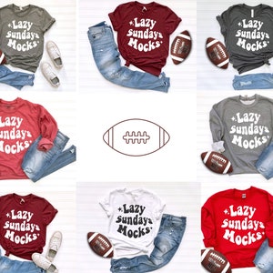 K&ouml;nnte beinhalten: Eine Auswahl an T-Shirts und Sweatshirts in verschiedenen Farben, darunter Grau, Burgunderrot und Rot, mit dem Text "Lazy Sundays Mocks" in einem Retro-Schriftstil. Jedes Shirt wird mit blauen Jeans, einem Football und Turnschuhen kombiniert.