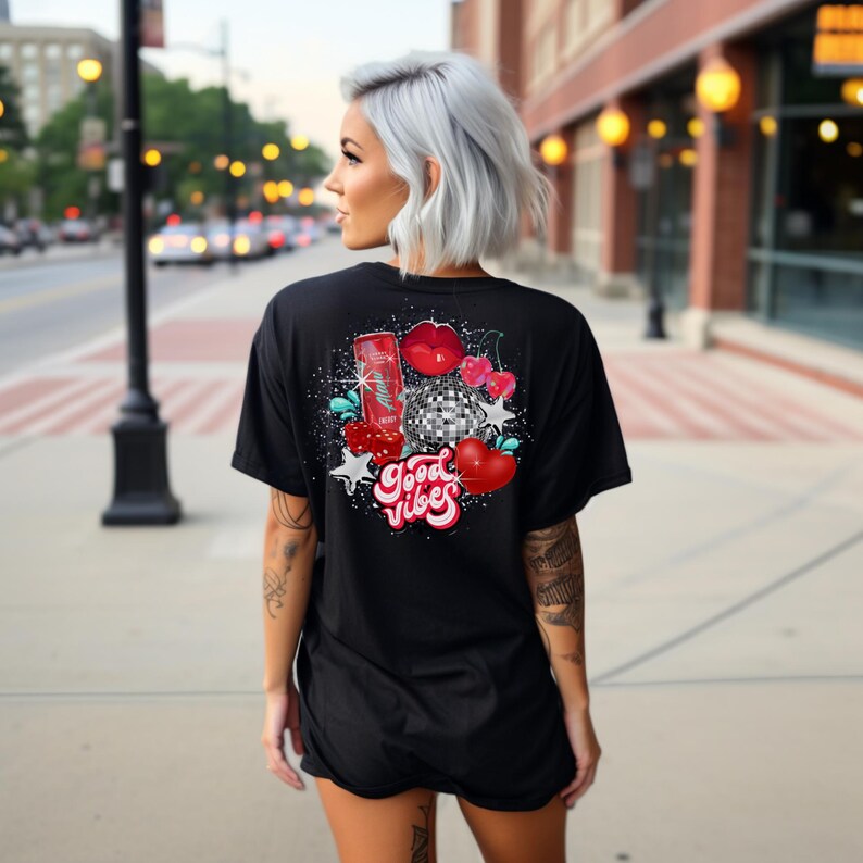 May include: Black t-shirt with a graphic print of a red can, a disco ball, cherries, and lips. The text "Good Vibes" is printed in red and white.