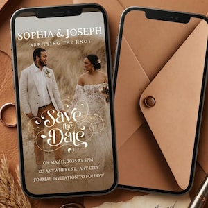 以下が含まれることがあります： 結婚式の招待状が表示された2台のスマートフォン。1台の電話には「Sophia & Joseph are tying the knot」と「Save the Date」というテキストが表示されたカップルが写っています。もう1台の電話には、閉じられた封筒が表示されています。金の指輪、小麦、ワックスシール、ペンが表面にあります。