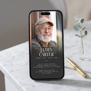 以下が含まれることがあります： スマートフォンには、ジェームズ・カーターの追悼のお知らせが表示されています。お知らせには、男性の肖像画、日付、イベントの詳細が含まれています。金のペンと緑の小さな花瓶がテーブルにあります。