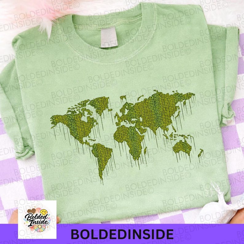 K&ouml;nnte beinhalten: Hellgr&uuml;nes T-Shirt mit einem Weltkarten-Design in Gr&uuml;nt&ouml;nen. Die Karte hat eine pixelige Textur mit Tropfeffekten. Der Text "BOLDEDINSIDE" ist am unteren Rand des Shirts aufgedruckt.