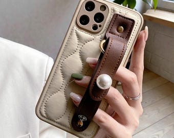 Funda de piel con correa de muñeca y perlas para iPhone 11, 12, 13, 14, 15, 16 y 17 (soporte y cobertura total)