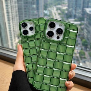 May include: Two green phone cases with a woven pattern. The cases are made of a transparent material, allowing the phone's camera and flash to be visible. The cases are designed to protect the phone from scratches and damage.