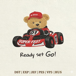 May include: An embroidered design of a light brown teddy bear wearing a red cap with the text BE READY, driving a red go-kart labeled 01 and SUPER FAST. Below the kart, the text reads Ready set Go! followed by file formats DST, EXP, JEF, PES, VP3, HUS.