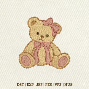May include: An embroidery design of a tan teddy bear featuring a pink bow on its head and a matching pink ribbon tied around its neck. The bear has pink paw pads on its feet and the text DST, EXP, JEF, PES, VP3, HUS is printed at the bottom.