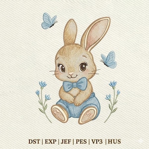 Può includere: Design ricamato di un coniglietto seduto con papillon blu e pantaloncini blu. Due farfalle blu e accenti floreali circondano il coniglietto. Il testo "DST | EXP | JEF | PES | VP3 | HUS" è in basso.