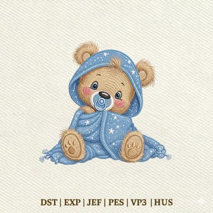 May include: An embroidered illustration of a light brown teddy bear wearing a blue hooded blanket with white stars. The bear has pink cheeks, blue eyes, and a blue pacifier. The text DST | EXP | JEF | PES | VP3 | HUS is printed below.