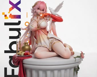 May include: A pink-haired anime-style figurine sits on a white circular pedestal. The figure wears a white and orange dress with gold accents, has a white dove on one shoulder, and is positioned next to a small table with fruit and candles.